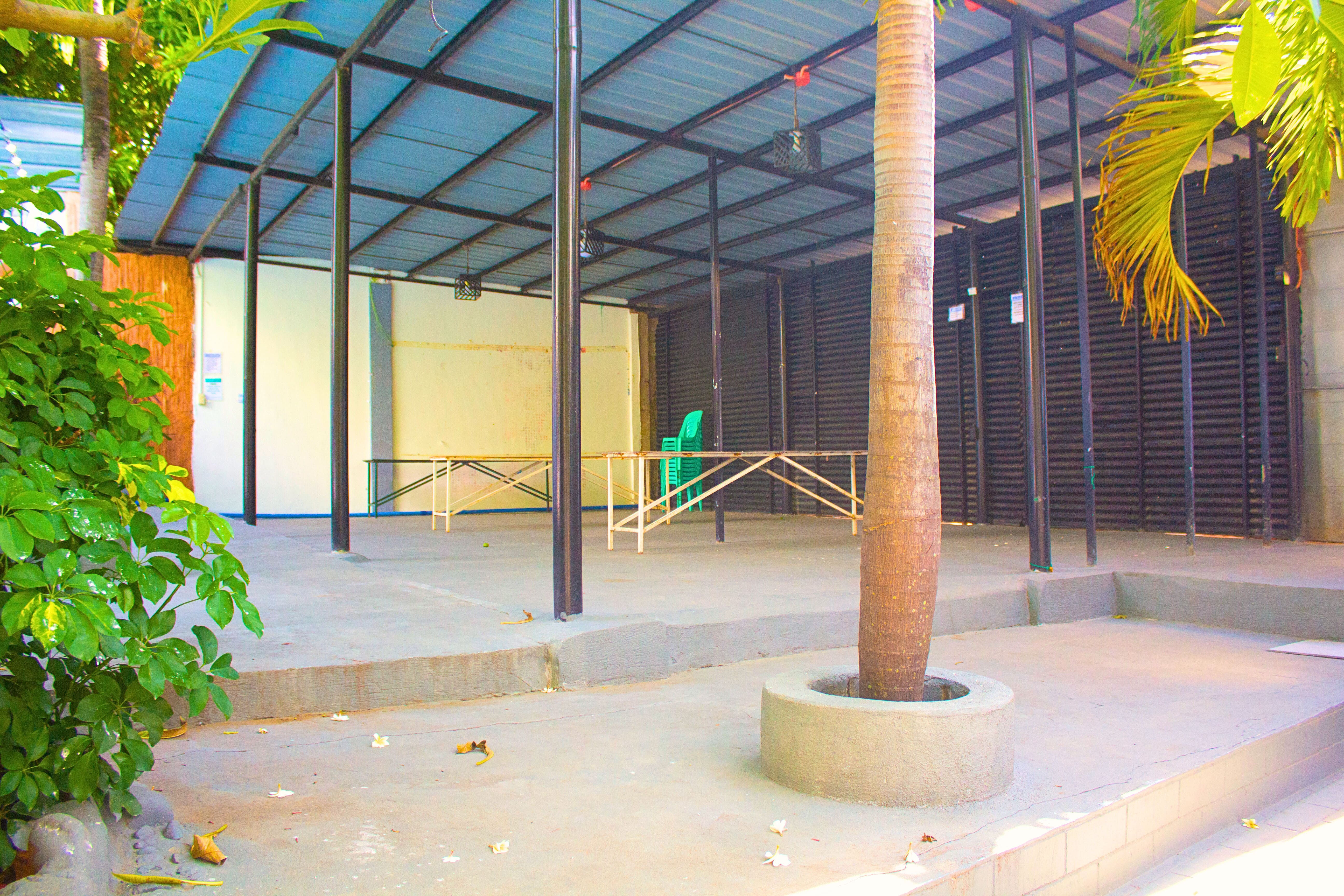 A cozy outdoor seating area with modern design elements, surrounded by plants and a black metal railing.