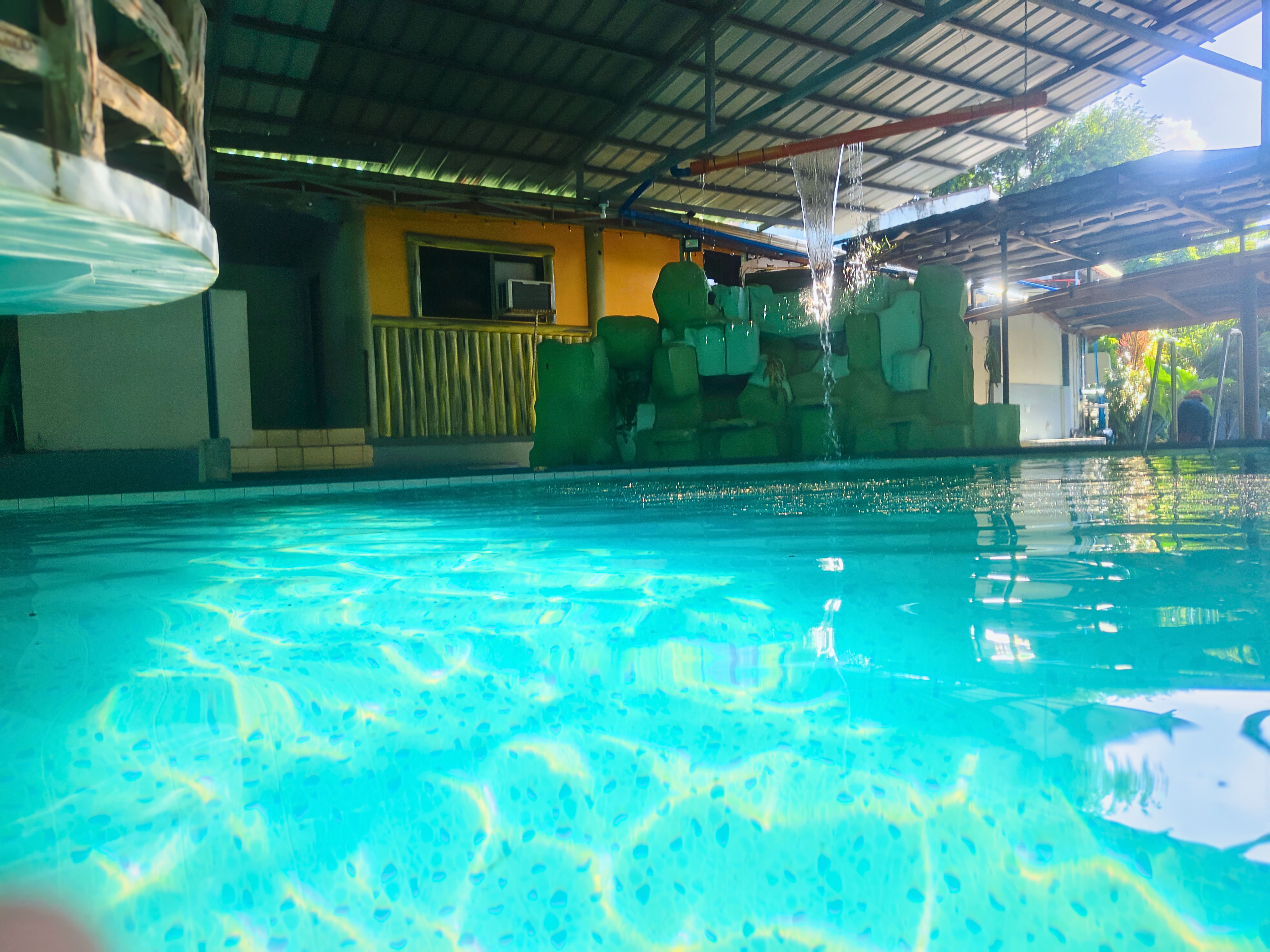 A cozy outdoor seating area with modern design elements, surrounded by plants and a black metal railing.